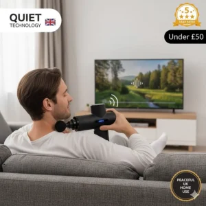 A man using a quiet technology massage gun on his shoulder while watching TV in a British living room, demonstrating low-noise operation for a peaceful home.