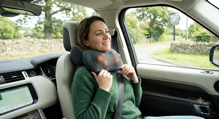 A premium car travel massage pillow resting on a car seat, providing ergonomic lumbar and neck support for long drives. car travel massage pillow