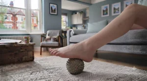 Compact foot massager being used discreetly under a home office desk for daily relief.